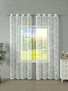 Detail of white French floral lace curtains showing grommet top design and sheer texture