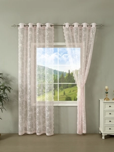 Detail of pink French lace curtains with floral embroidery and top metal grommets