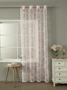 Detail of pink floral lace curtain with grommet top hanging on a silver metal rod