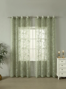 Detailed view of light green lace curtains with floral embroidery and silver metal rings