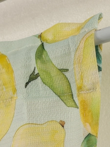 Close-up of lemon print fabric showing texture and rod pocket hanging detail