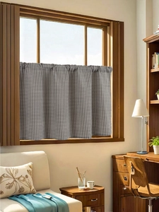 Detail of blue gingham fabric curtain hanging on a dark wood frame in a cozy home setting