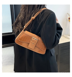 Detail of vintage brown crocodile embossed baguette bag with knotted strap shoulder detail