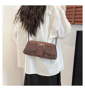 Close-up of brown faux leather underarm bag with crocodile pattern and metal buckle