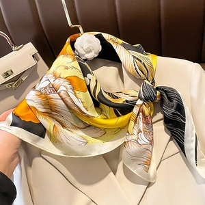 Elegant silk-like square scarf with floral print styled on a white professional blazer
