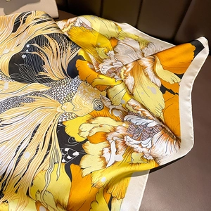 Detailed view of silk square scarf featuring orange koi fish and floral patterns on satin