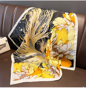 Detailed texture of a silk square scarf with goldfish and floral patterns on a sofa
