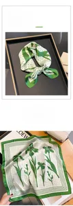 Detailed view of a green floral silk scarf with polka dots and lily pattern