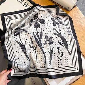 Detailed close-up of a premium silk scarf with black and white iris flower and polka dot pattern