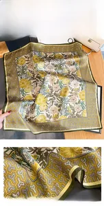 Detailed view of yellow daisy print silk scarf with green geometric border and fine edges