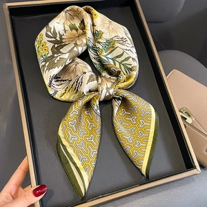 Silk twilly scarf with yellow chrysanthemum and grey geometric patterns on a tray