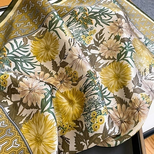 Detail of silk scarf with chrysanthemum patterns and mustard yellow rolled edges