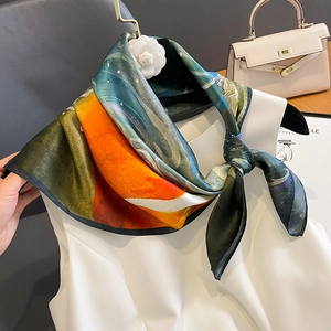 Seidenschal mit Ölgemälde-Print und Kamelien-Brosche auf weißer Kleidung am Bügel