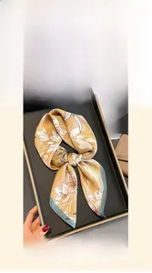 Vue détaillée d'un foulard en soie de 70x70cm avec fond champagne et motifs de lys blancs