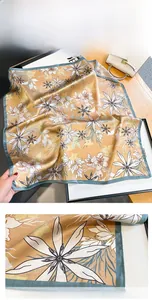Détail macro de l'imprimé lys orange sur foulard en soie de luxe avec bords roulottés