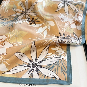Détail d'un foulard élégant en soie avec imprimés de lys et texture soyeuse