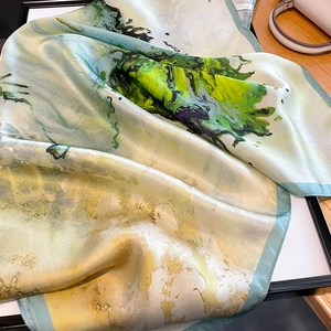 Detail eines Seidenschals mit Aquarellmuster, glatter Textur und hellblauen Saumkanten