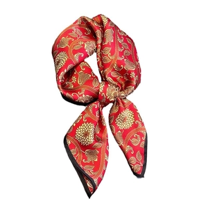 Red silk square scarf with golden floral patterns and elegant satin finish on white background