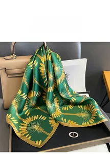 Detail of green silk scarf with yellow floral pattern draped elegantly in a luxury setting