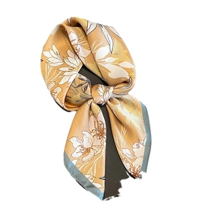 Élégant foulard en soie dorée avec motifs floraux et bordure grise sur fond blanc