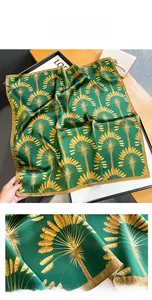 Detail of silk scarf with golden palm leaf patterns and refined hand-rolled edges