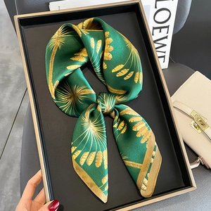 Green silk scarf with gold palm leaf patterns elegantly displayed on a black tray