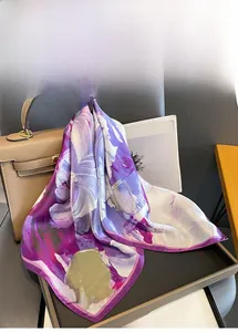 Detail of a luxury silk square scarf with purple floral patterns draped on a handbag