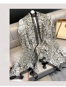 Detail of elegant black and white camellia floral print on sheer beach shawl scarf