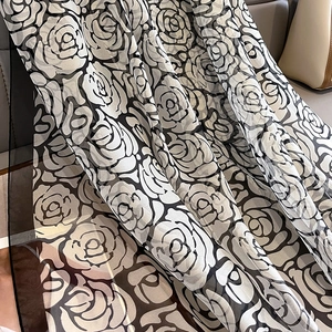 Close-up of black and white camellia floral pattern on lightweight semi-transparent silk scarf