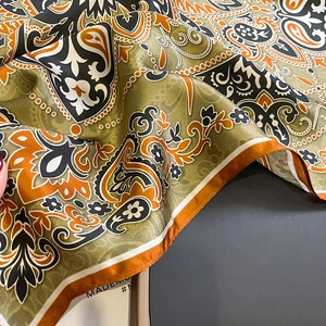 Detail of silk scarf showing vintage paisley patterns and smooth glossy satin texture