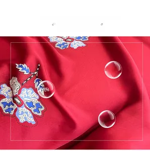 Detail of red floral faux silk fabric showing smooth texture and soft breathability