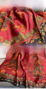 Close-up of red silk scarf showing floral phoenix print and neat hemmed edges