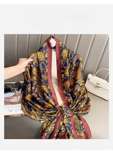 Detail of navy silk scarf with vintage Paisley patterns and burgundy hem, elegant style