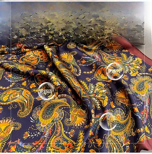 Macro detail of dark blue paisley silk-like scarf showing smooth texture and pattern