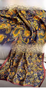 Detail of navy blue silk scarf with paisley patterns showing fabric texture and hem stitching