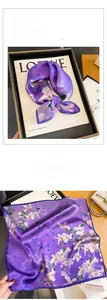 Close-up of premium purple silk scarf featuring elegant floral lily prints and soft texture