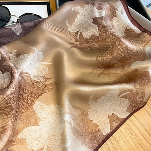 Macro shot of elegant champagne silk scarf with white orchids and brown edges