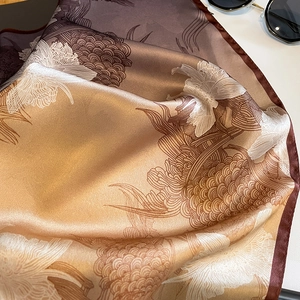 Elegant silk floral print scarf in gradient brown and gold with silky texture and sheen