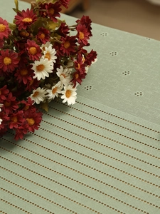 Close-up of sage green hollow lace tablecloth with detailed geometric weaving patterns