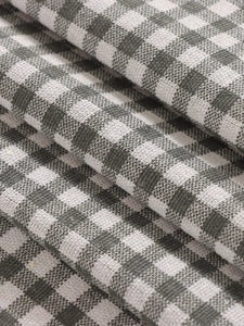 Close-up detail of grey and white gingham fabric with natural folds and soft texture