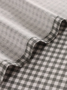 Detailed macro view of the grey and white checkered fabric with fine stitching