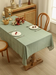 Detail of sage green lace tablecloth with hollow stripe texture and floral borders