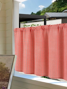 Detail of red and white gingham fabric texture and rod pocket design on kitchen cafe curtain