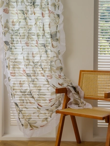 Detail of floral crochet curtain with green leaves and ruffles in warm natural light