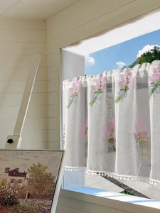 Detail of lavender embroidery and white pom-pom fringe on semi-sheer coffee curtains