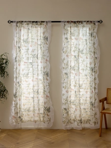 Detail of floral translucent curtains with ruffled edges in a rustic farmhouse style