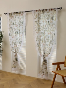Detail of floral chiffon curtains with elegant leaf patterns and wavy lace edging