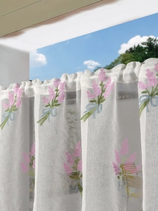 Close-up of lavender embroidery and blue ribbon on a semi-transparent white curtain
