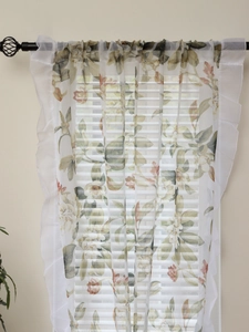 Close-up of floral print sheer curtain with white ruffles and vintage patterns