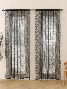 Detail of black floral mesh lace curtain showing elegant wavy edges and sheer texture